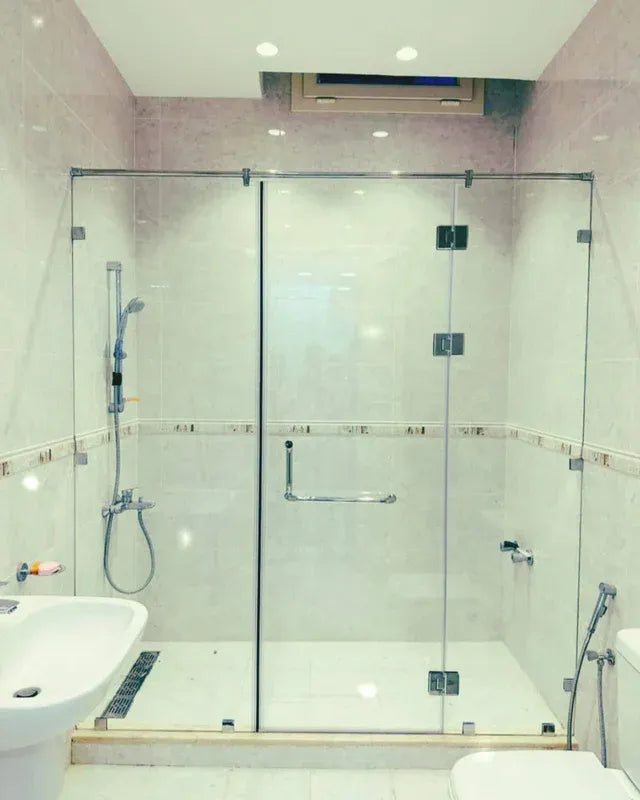 Premium custom frameless glass shower enclosure with heavy tempered safety glass and rust-proof chrome hardware installed by Al Najm glass and mirror in a Doha villa.