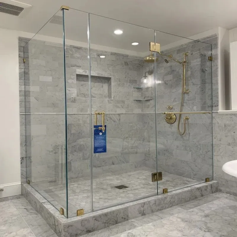 Luxury shower glass Doha cabin enclosure manufactured by Al Najm Glass & Mirror Company. Modern bathroom layout featuring a premium clear tempered glass sliding shower door system with high-end polished brass hardware, frame-less profiles, and optimized waterproofing in Qatar.