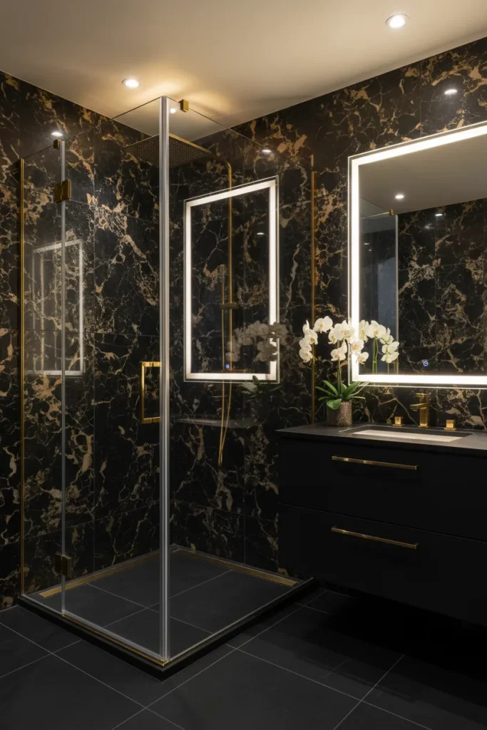 Luxury modern bathroom featuring a custom rectangular LED backlit smart vanity mirror and a frameless corner glass shower enclosure with gold hardware clips installed by Al Najm Glass and Mirror against black marble tiles in a Doha villa, Qatar.